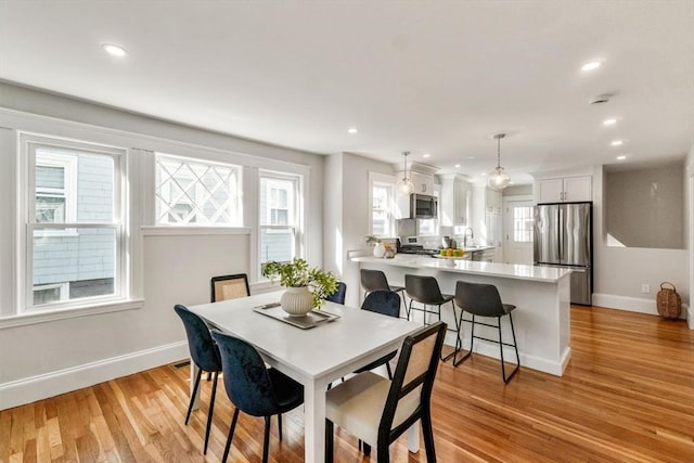 dining area with recessed lighting, light wood-style flooring, and baseboards