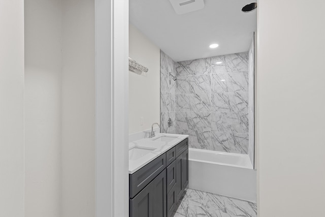 bathroom with tiled shower / bath combo and vanity