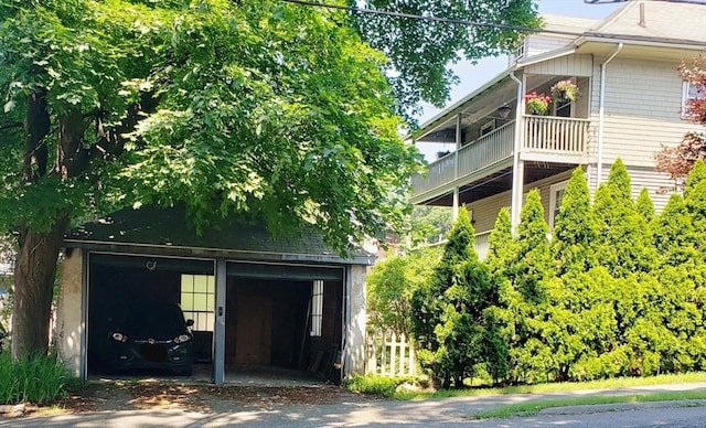 exterior space featuring a detached garage, an outdoor structure, and a balcony