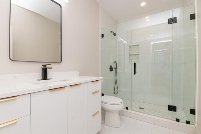 bathroom with tile patterned floors, a shower with door, vanity, and toilet