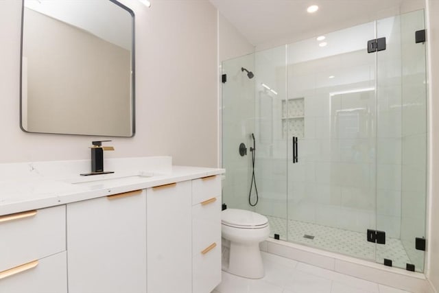 bathroom featuring tile patterned floors, vanity, toilet, and a shower with shower door