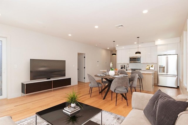 living room with sink and light hardwood / wood-style floors