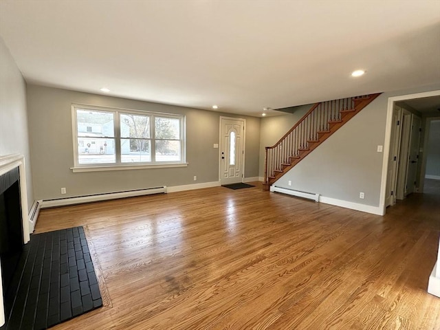 unfurnished living room featuring light hardwood / wood-style floors and a baseboard heating unit