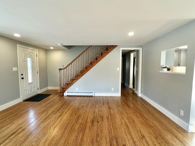 foyer with light hardwood / wood-style flooring and a baseboard heating unit