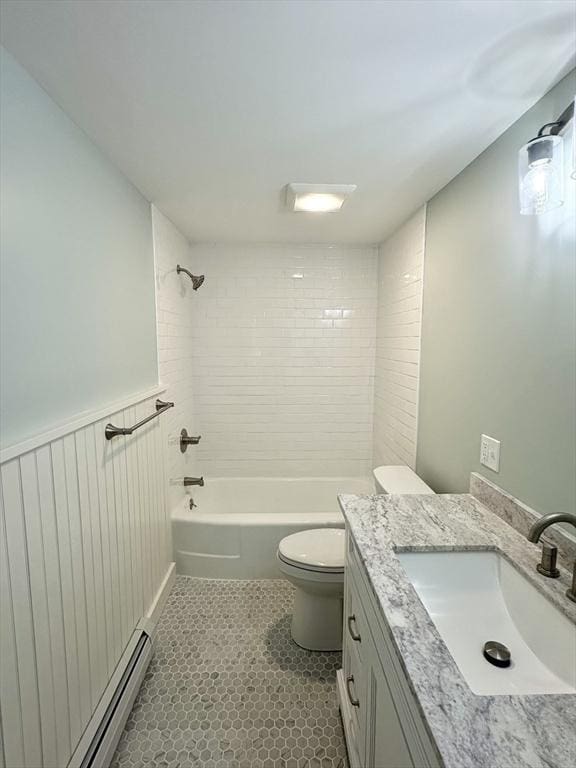 full bathroom with baseboard heating, tile patterned floors, toilet, vanity, and tiled shower / bath