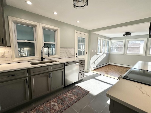 kitchen with backsplash, dishwasher, sink, and a baseboard radiator