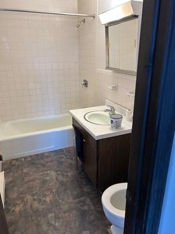 bathroom featuring shower / washtub combination, vanity, and toilet