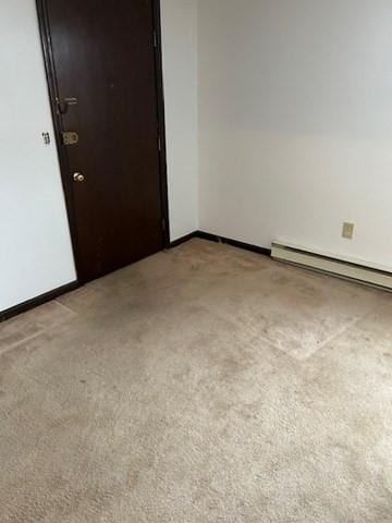 empty room featuring baseboards and light colored carpet