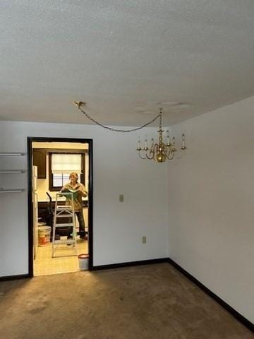 empty room featuring baseboards and a textured ceiling