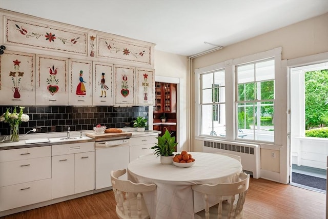 15 Brier Rd, Gloucester, MA 01930 - kitchen featuring radiator, white dishwasher, light wood-type flooring, decorative backsplash, and white cabinets