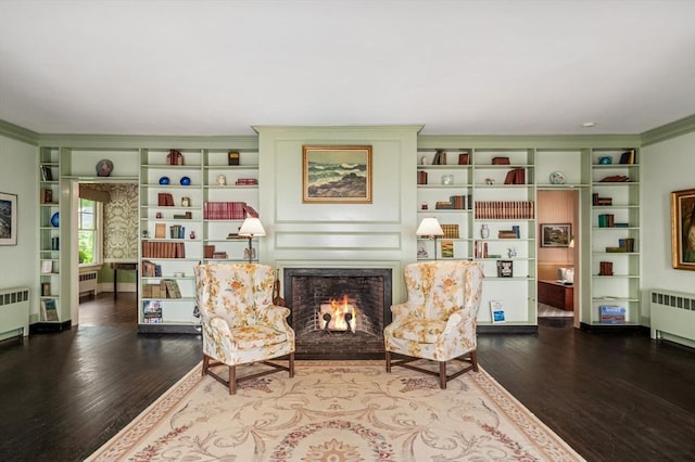 15 Brier Rd, Gloucester, MA 01930 - living area with radiator, wood finished floors, a fireplace with flush hearth, and crown molding
