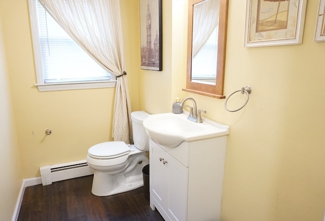 bathroom with a baseboard heating unit, vanity, hardwood / wood-style flooring, and toilet