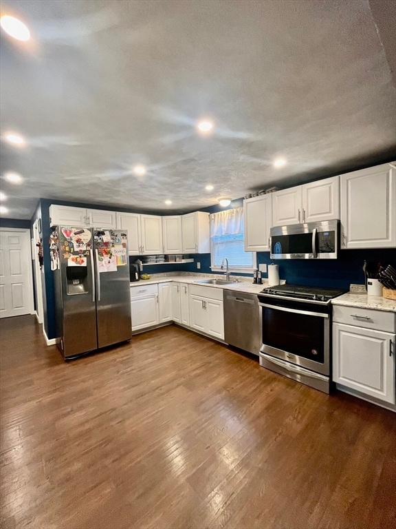 kitchen featuring dark hardwood / wood-style flooring, white cabinetry, and stainless steel appliances