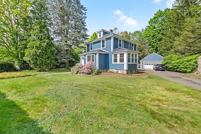 view of front of home featuring an outdoor structure, a garage, and a front lawn