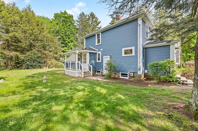 rear view of house with a yard and a sunroom