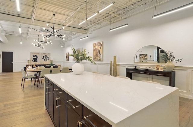 147 Sherman St Unit 201, Cambridge, MA 02140 - kitchen featuring open floor plan, hanging light fixtures, light wood-style floors, a center island, and a chandelier