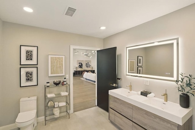 147 Sherman St Unit 201, Cambridge, MA 02140 - bathroom featuring double vanity, toilet, a chandelier, ensuite bath, and recessed lighting