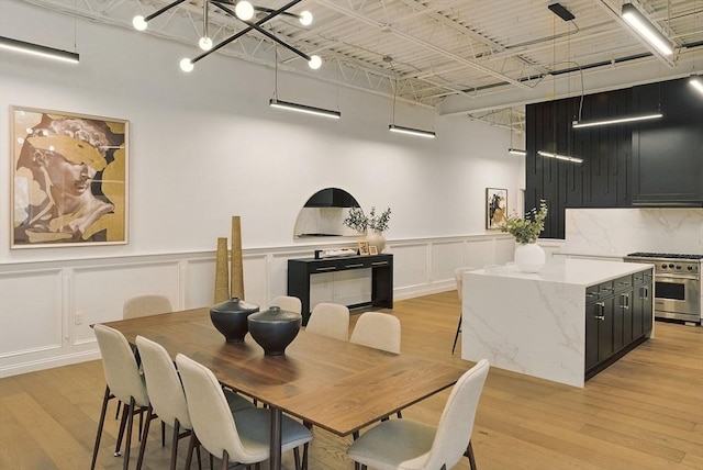 147 Sherman St Unit 201, Cambridge, MA 02140 - dining space featuring a decorative wall, light wood finished floors, and a wainscoted wall