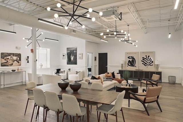 147 Sherman St Unit 201, Cambridge, MA 02140 - dining area with a chandelier, wood finished floors, and a high ceiling