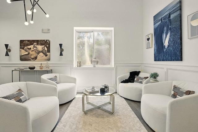 147 Sherman St Unit 201, Cambridge, MA 02140 - living room featuring a decorative wall, wood finished floors, wainscoting, and a chandelier