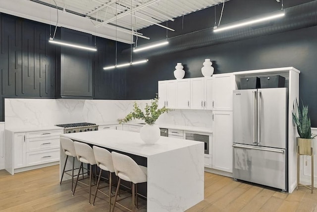 147 Sherman St Unit 201, Cambridge, MA 02140 - kitchen with freestanding refrigerator, tasteful backsplash, light countertops, and light wood finished floors