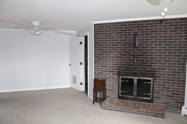 unfurnished living room featuring a ceiling fan, crown molding, a brick fireplace, baseboards, and carpet