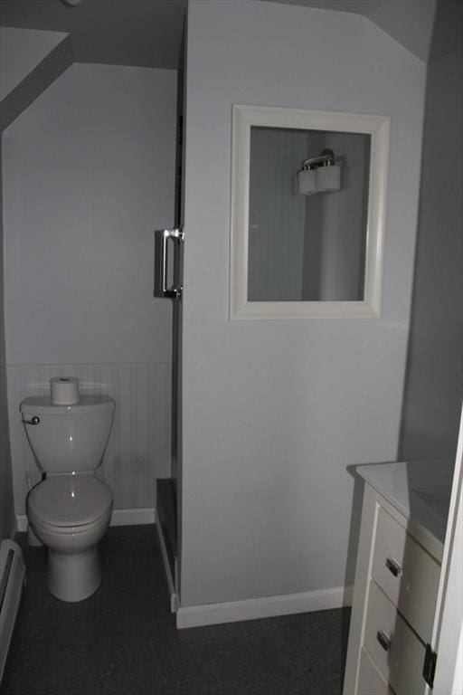bathroom featuring vanity, wainscoting, toilet, a baseboard radiator, and a stall shower