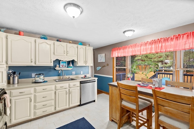 kitchen featuring a textured ceiling, stainless steel appliances, and sink