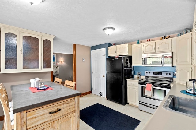 kitchen featuring sink, a textured ceiling, light tile patterned flooring, and stainless steel appliances