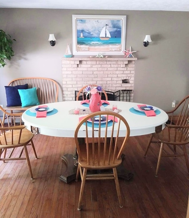 dining area featuring wood-type flooring and a fireplace