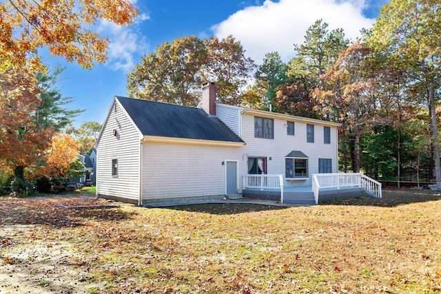 back of house featuring a wooden deck and a yard