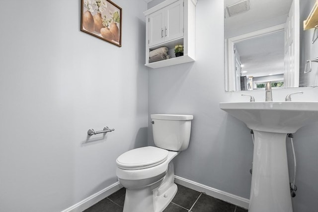 half bath with tile patterned floors, visible vents, baseboards, and toilet