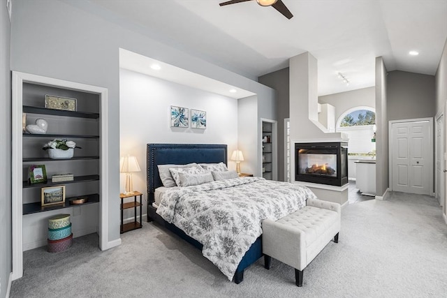 bedroom with baseboards, lofted ceiling, recessed lighting, a multi sided fireplace, and light carpet