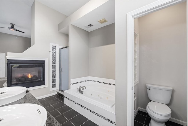 full bath with a glass covered fireplace, tile patterned floors, visible vents, and a stall shower