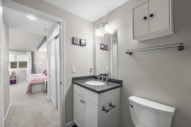 half bathroom with toilet, vanity, and baseboards