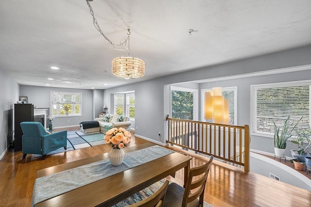 dining room with visible vents, hardwood / wood-style floors, recessed lighting, a fireplace, and baseboards