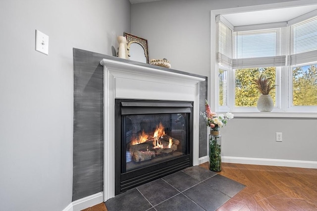 room details featuring baseboards and a fireplace with flush hearth