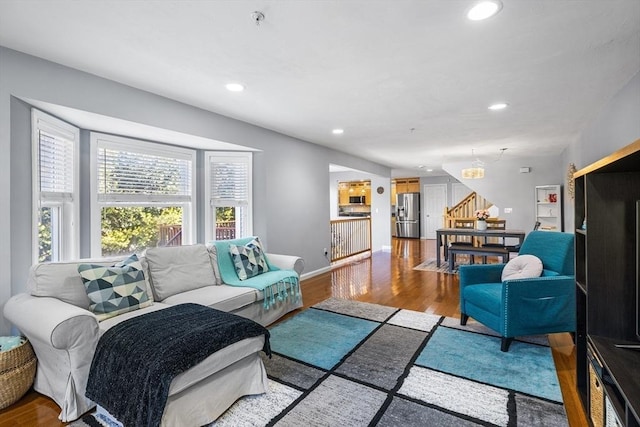 living area with stairway, recessed lighting, baseboards, and wood finished floors