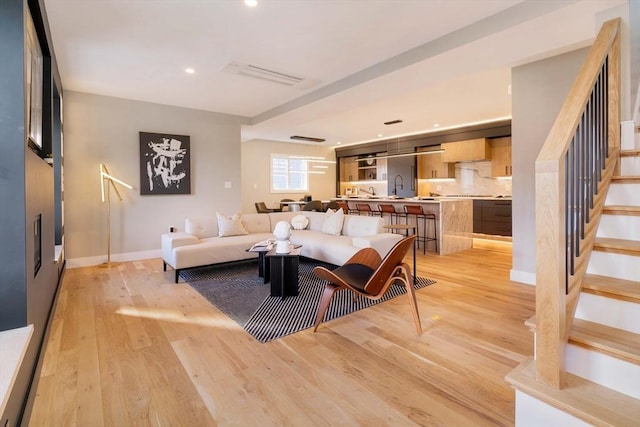 living room featuring light hardwood / wood-style flooring and sink