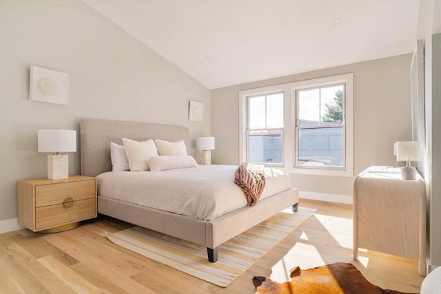 bedroom with light hardwood / wood-style flooring and lofted ceiling