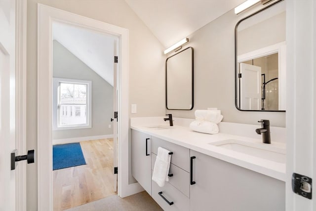 bathroom featuring vanity, vaulted ceiling, and hardwood / wood-style flooring