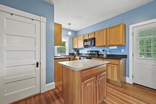 23 Starbird St, Lowell, MA 01854 - kitchen with black microwave, electric stove, light wood-type flooring, a center island, and pendant lighting