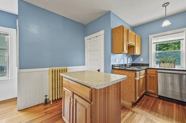 23 Starbird St, Lowell, MA 01854 - kitchen featuring stainless steel dishwasher, radiator, light wood finished floors, wainscoting, and a kitchen island