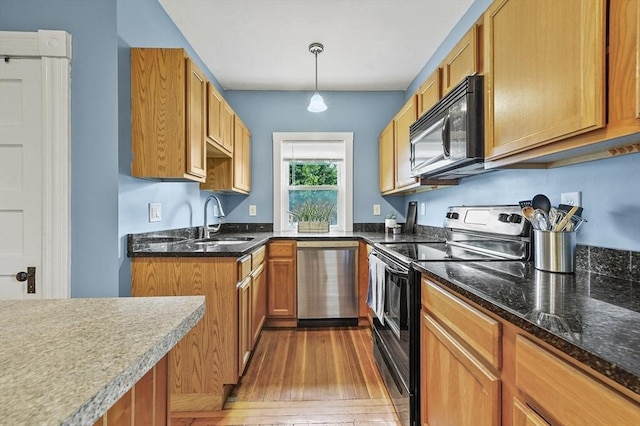 23 Starbird St, Lowell, MA 01854 - kitchen with dishwasher, black microwave, electric stove, light wood-style floors, and dark stone counters