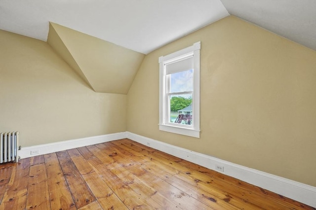 23 Starbird St, Lowell, MA 01854 - bonus room featuring radiator heating unit, vaulted ceiling, and hardwood / wood-style floors