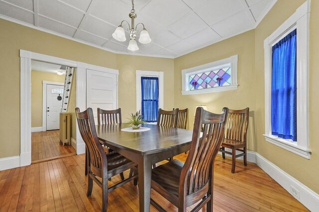 23 Starbird St, Lowell, MA 01854 - dining space with light wood finished floors, a chandelier, and ornamental molding