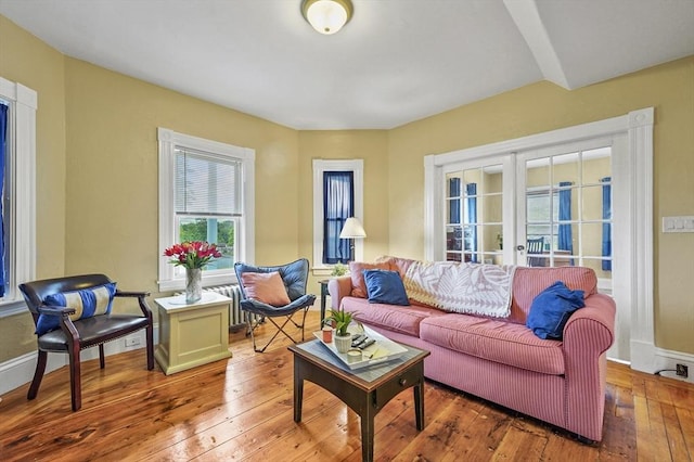 23 Starbird St, Lowell, MA 01854 - living area featuring french doors, wood-type flooring, and radiator heating unit
