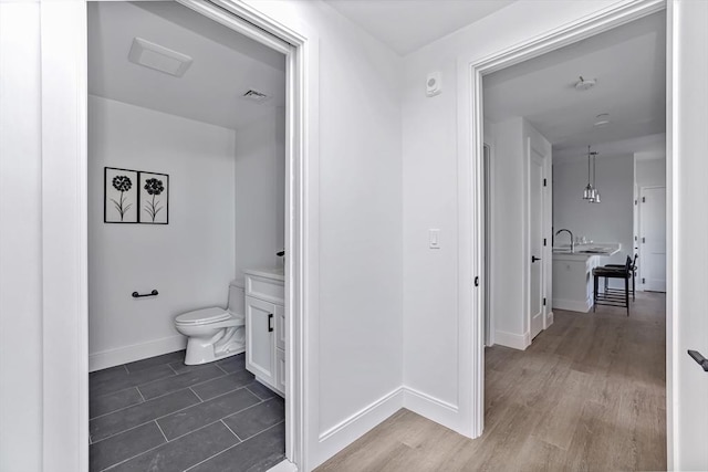 bathroom with sink, hardwood / wood-style floors, and toilet