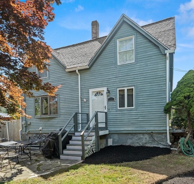 91 Bartholomew St, Peabody, MA 01960 - back of house featuring a chimney, a patio area, and roof with shingles
