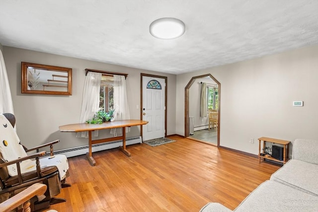 91 Bartholomew St, Peabody, MA 01960 - foyer with a baseboard radiator, arched walkways, light wood finished floors, and healthy amount of natural light